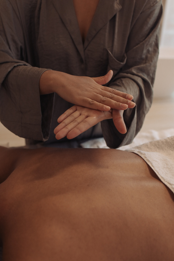 Woman Putting Massage Oil on Back